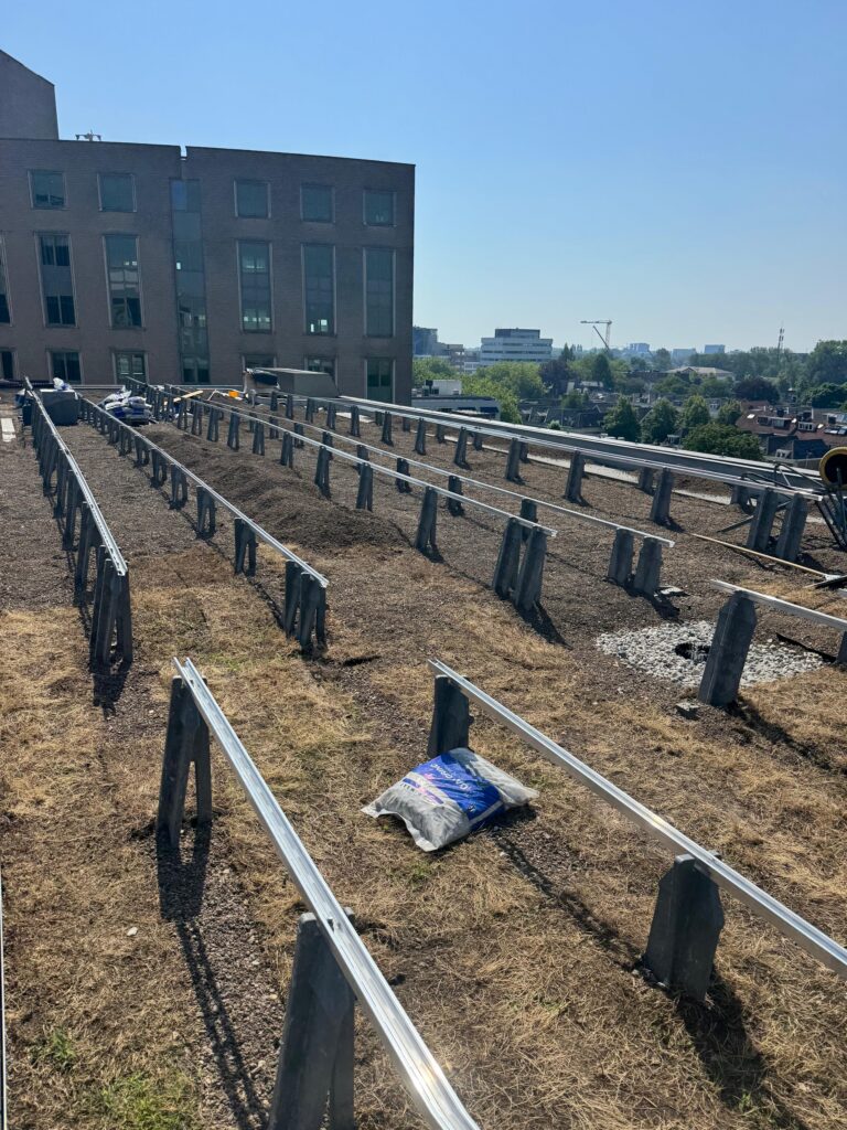 Sedumdak met montagerails en ballastblokken, klaar voor de panelen