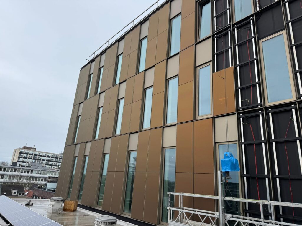 Gevelvlak met glas-glaspanelen tegen blauwe lucht
